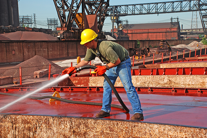 Deckhand washing down cargo hold